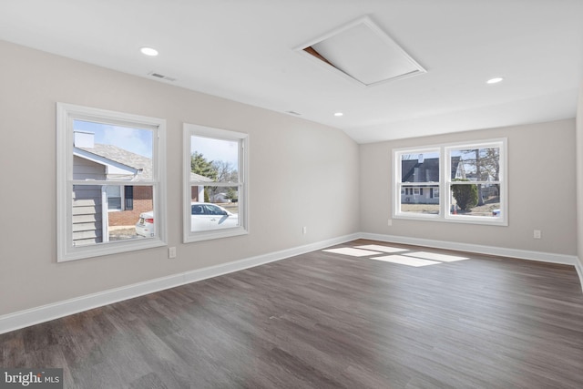 empty room featuring visible vents, baseboards, and attic access