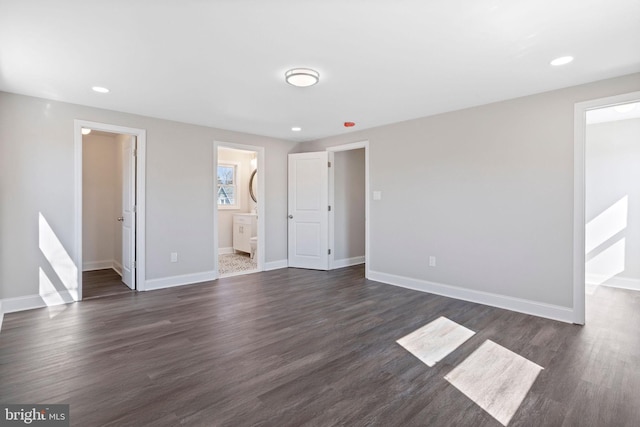 unfurnished bedroom featuring a walk in closet, recessed lighting, dark wood-style floors, and baseboards