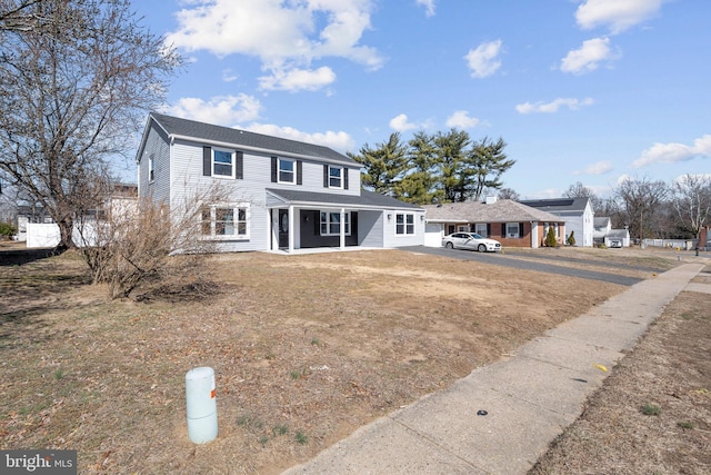 view of front of home featuring covered porch and a front lawn