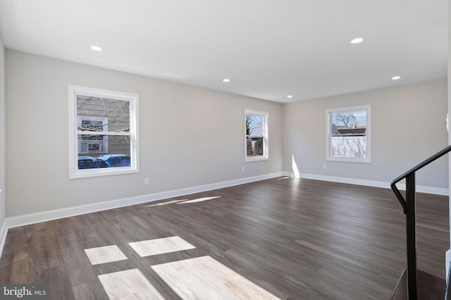 unfurnished living room with recessed lighting, baseboards, and dark wood-style flooring