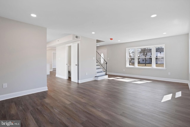 unfurnished living room with recessed lighting, baseboards, dark wood-style floors, and stairs