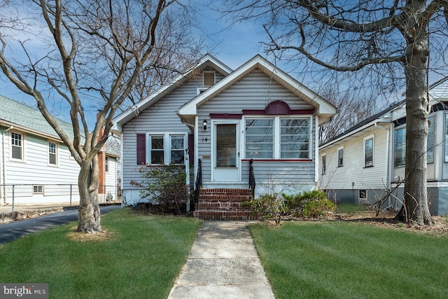 bungalow-style house with entry steps and a front lawn