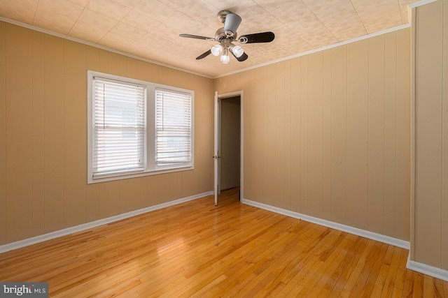 unfurnished room with baseboards, a ceiling fan, light wood-style floors, and ornamental molding