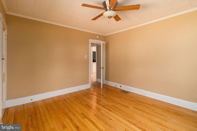 empty room featuring visible vents, baseboards, ceiling fan, light wood-style floors, and crown molding