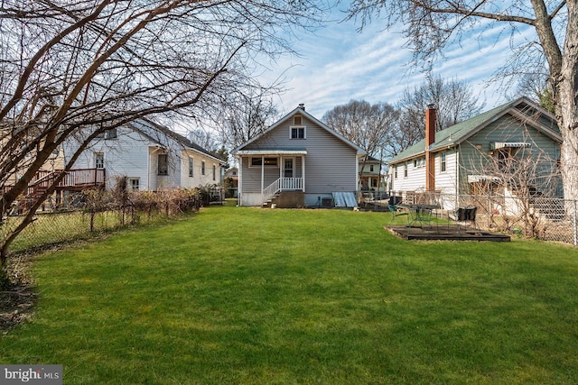 rear view of house with a yard and fence