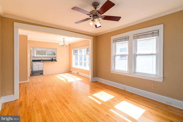 unfurnished living room with light wood-type flooring, baseboards, crown molding, and ceiling fan with notable chandelier