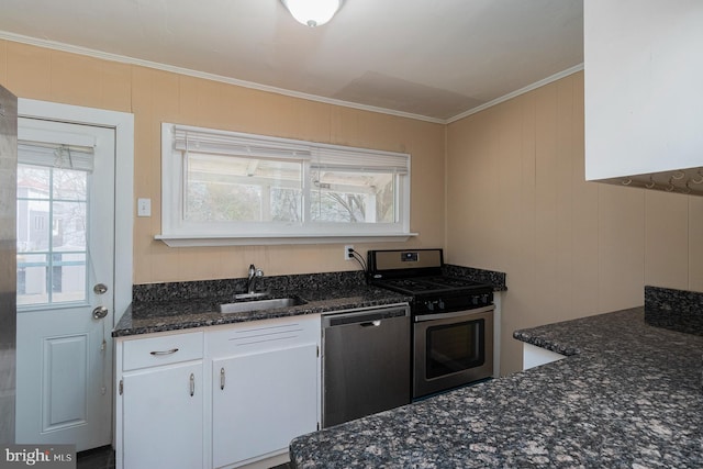 kitchen with crown molding, dark stone countertops, appliances with stainless steel finishes, white cabinetry, and a sink