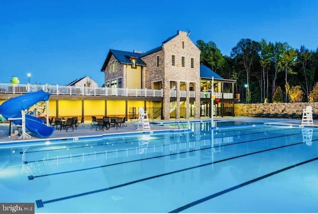 pool with a water slide and fence