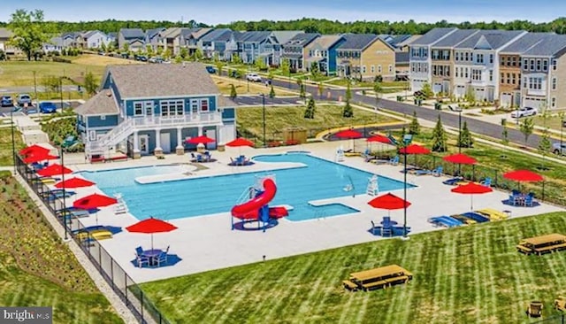 pool featuring a residential view, a patio, and fence