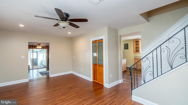 unfurnished room with stairway, baseboards, a ceiling fan, and wood finished floors