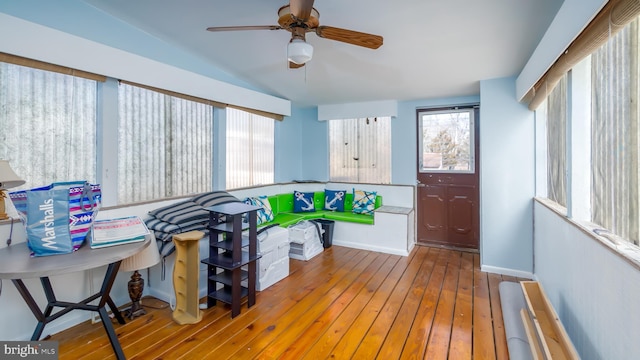 interior space with baseboards, ceiling fan, vaulted ceiling, and hardwood / wood-style flooring