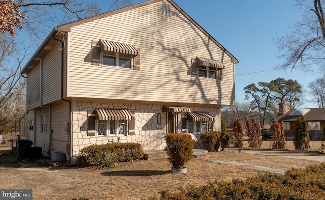 view of side of property with central air condition unit