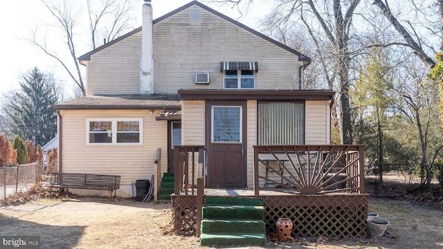 rear view of property featuring fence and a wooden deck