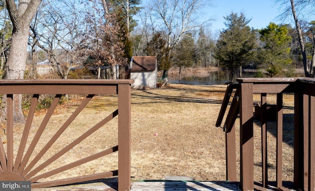 view of yard featuring an outbuilding, a shed, and a water view