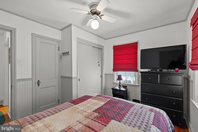 802 E 11th Ave, York, PA 17402 - bedroom featuring wood finished floors, a ceiling fan, a closet, wainscoting, and crown molding