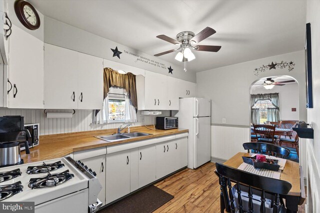 802 E 11th Ave, York, PA 17402 - kitchen with white appliances, a wainscoted wall, ceiling fan, a sink, and white cabinetry