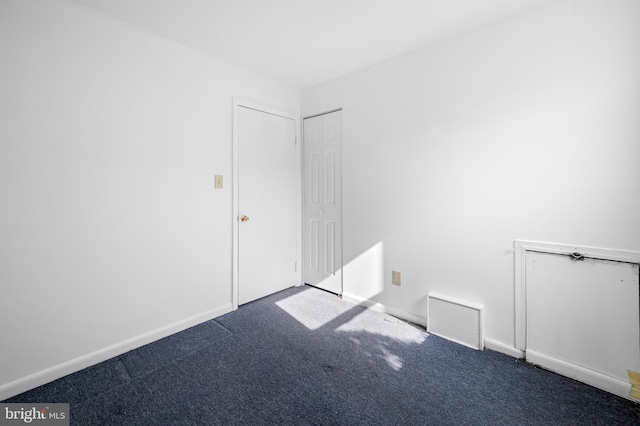 unfurnished room with baseboards and carpet