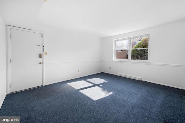 spare room featuring dark colored carpet, visible vents, and baseboards