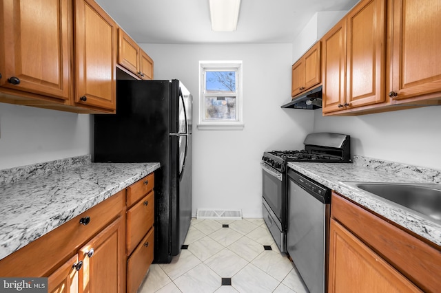 kitchen featuring visible vents, under cabinet range hood, freestanding refrigerator, gas stove, and dishwasher