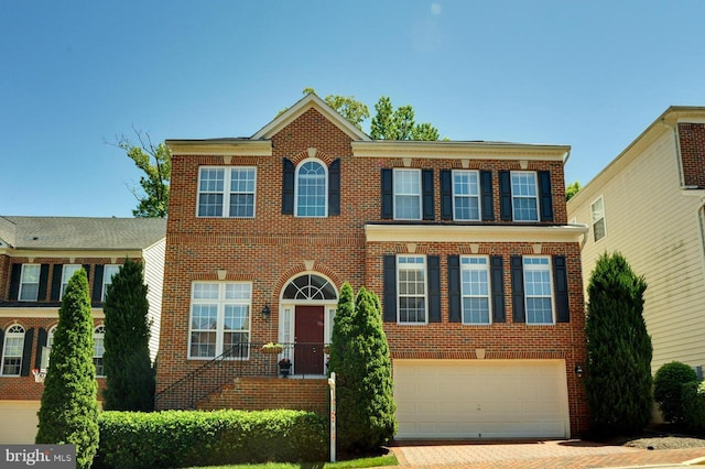 view of front of house with a garage, brick siding, and driveway