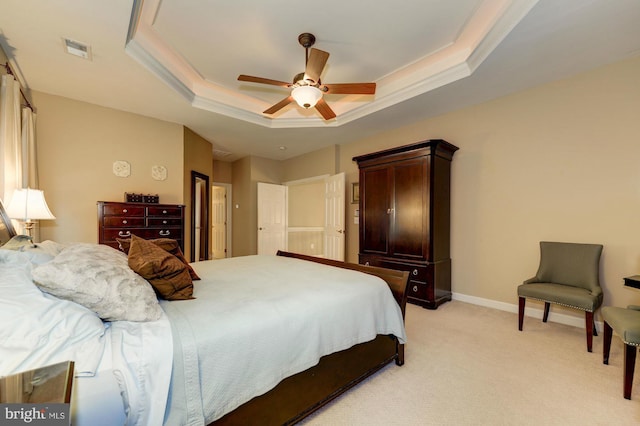 bedroom featuring visible vents, baseboards, crown molding, a raised ceiling, and light colored carpet