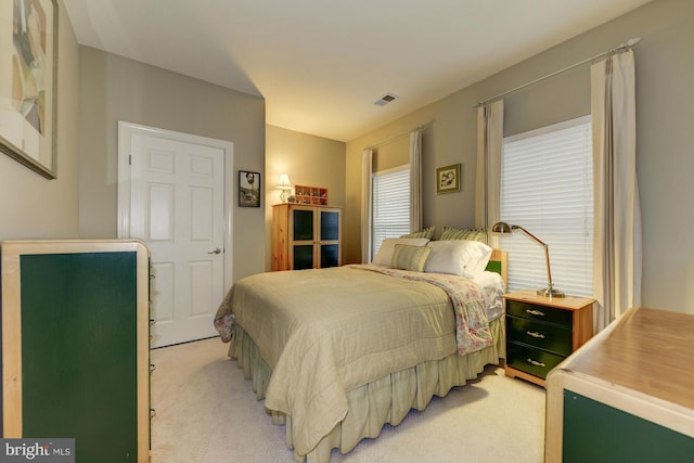 bedroom with visible vents and light carpet