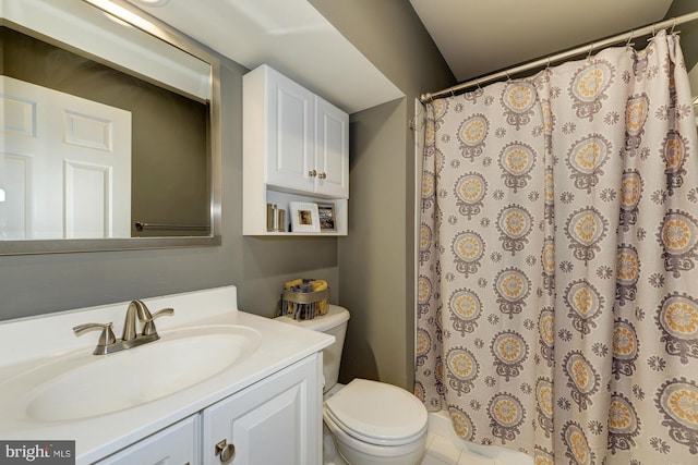 bathroom with curtained shower, toilet, and vanity