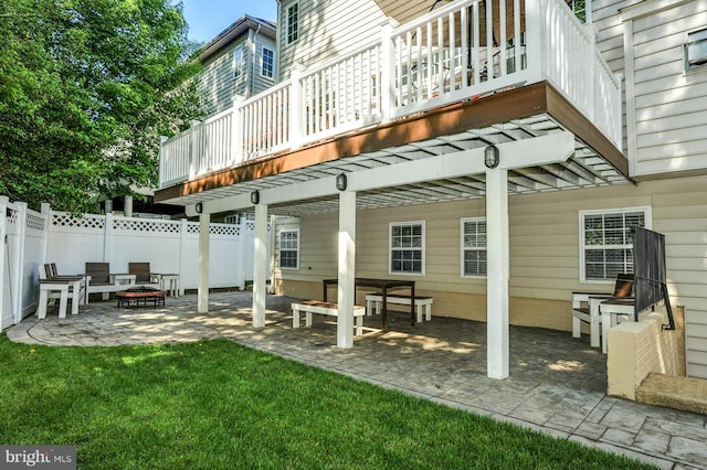 rear view of house featuring a patio area, fence, a lawn, and an outdoor fire pit