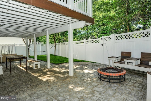 view of patio / terrace with a fire pit, a fenced backyard, and a pergola