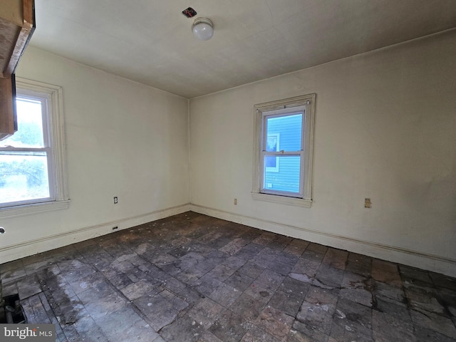 spare room with baseboards