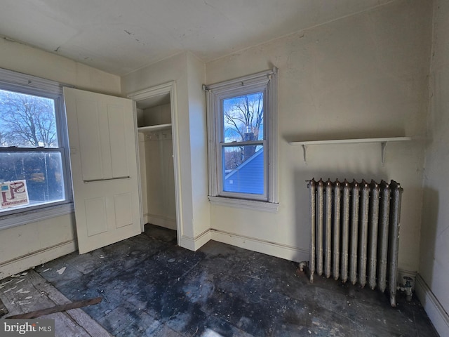 unfurnished bedroom with baseboards and radiator heating unit