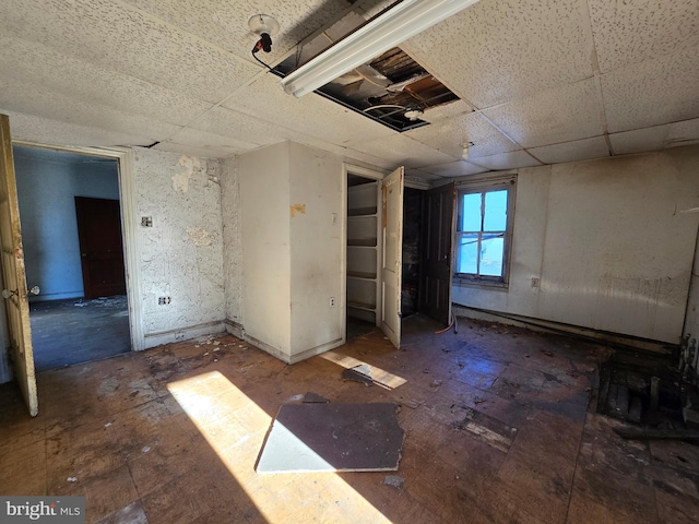 unfurnished room featuring a drop ceiling