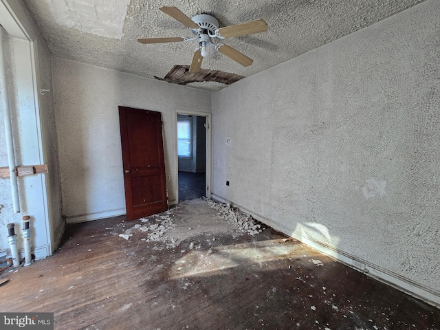 interior space featuring a textured ceiling, a ceiling fan, and wood finished floors