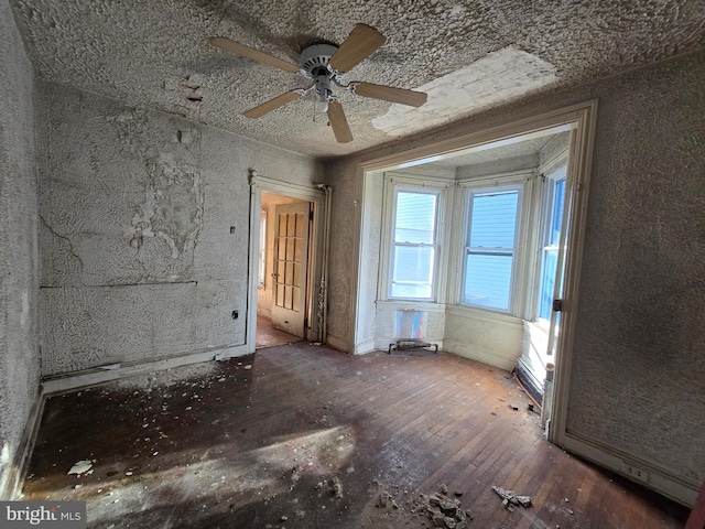 empty room with a ceiling fan and hardwood / wood-style floors