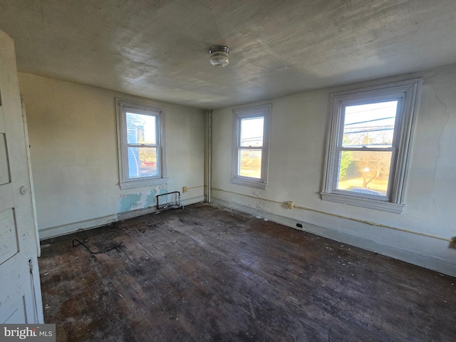 empty room featuring a healthy amount of sunlight and wood finished floors