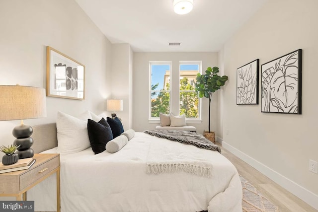 bedroom featuring visible vents, baseboards, and light wood-style flooring