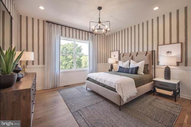 bedroom featuring wallpapered walls, baseboards, and hardwood / wood-style floors