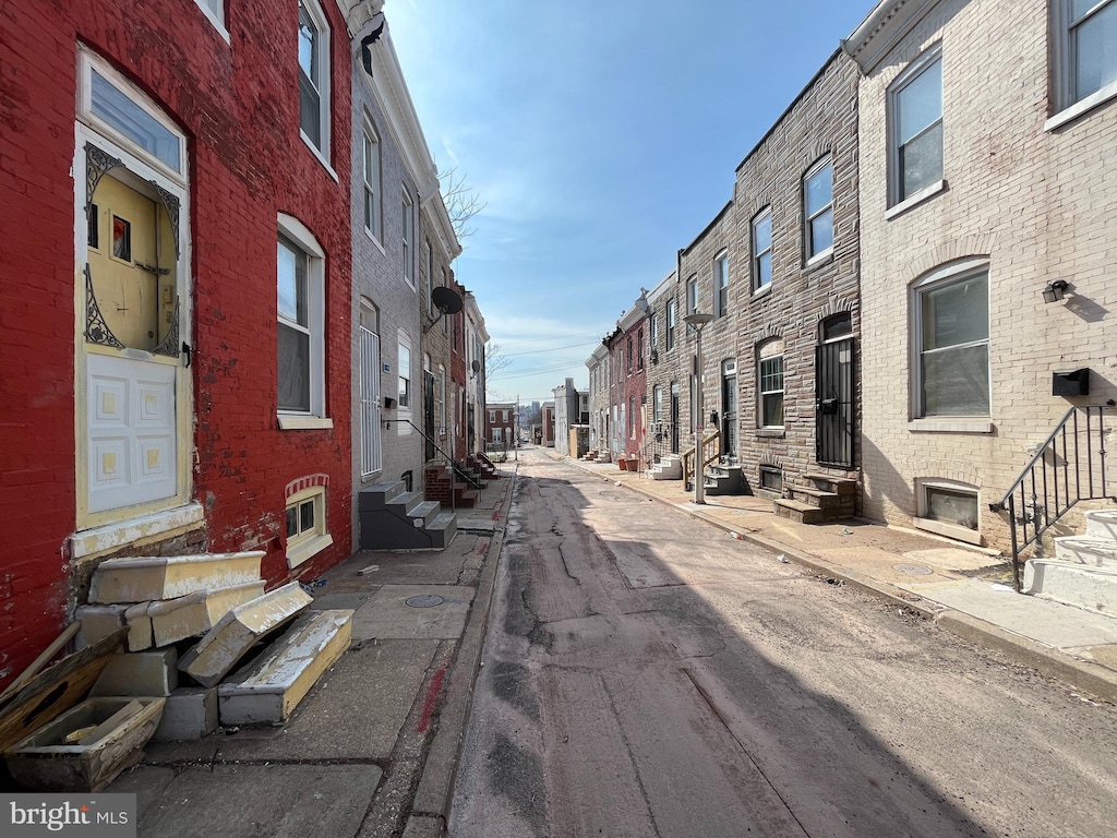 view of street with curbs, entry steps, and sidewalks