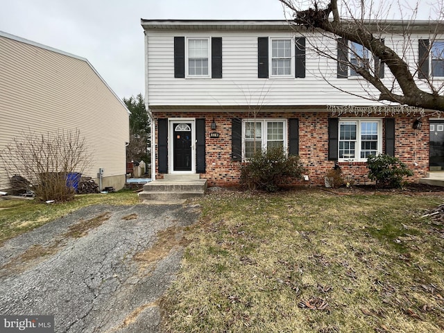 colonial home with brick siding and a front lawn