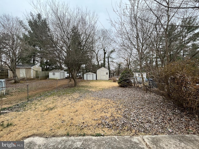 view of yard with a shed, an outdoor structure, and fence