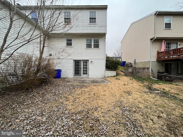 rear view of property featuring french doors and fence