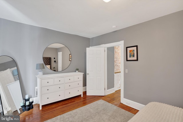 bedroom featuring baseboards and wood finished floors