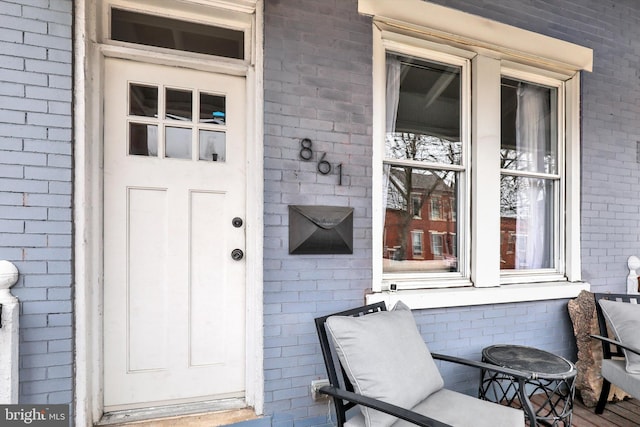 view of exterior entry with brick siding