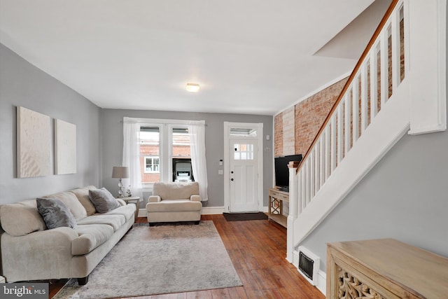 living room featuring stairs, visible vents, dark wood-style flooring, and baseboards