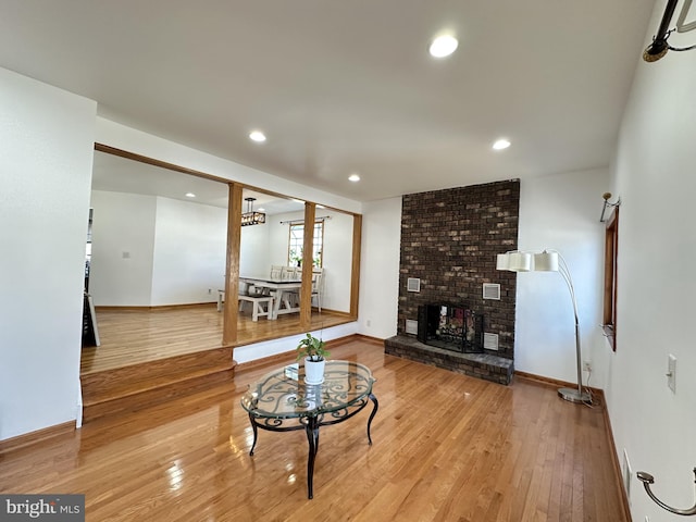 living area with hardwood / wood-style floors, recessed lighting, baseboards, and a fireplace