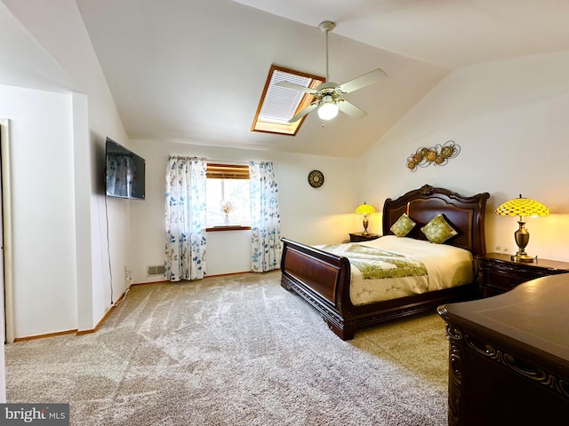 carpeted bedroom with visible vents, lofted ceiling with skylight, baseboards, and ceiling fan