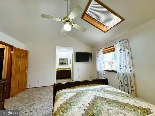 unfurnished bedroom featuring connected bathroom, vaulted ceiling with skylight, a ceiling fan, and carpet flooring