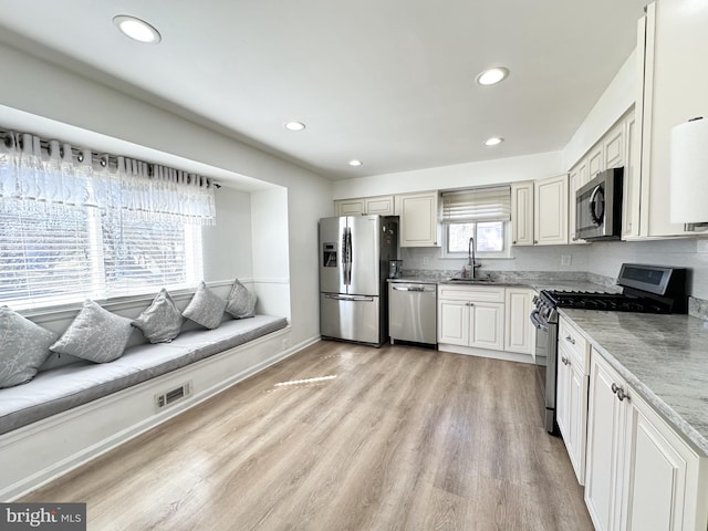 kitchen with light wood finished floors, visible vents, recessed lighting, appliances with stainless steel finishes, and a sink