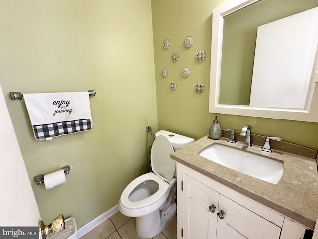 half bathroom with tile patterned floors, baseboards, toilet, and vanity