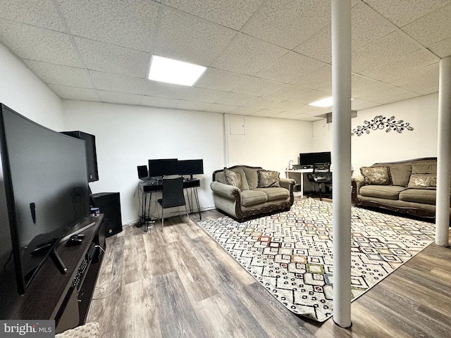 living area featuring wood finished floors and a drop ceiling